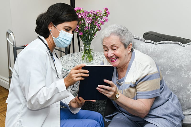 Enfermera y paciente revisan contenido en una tableta
