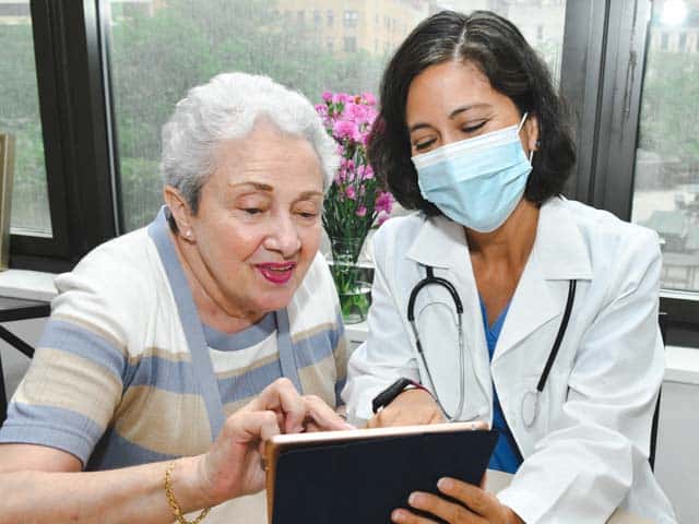 FindProvider_640x480 Provider assisting elderly patient with tablet device